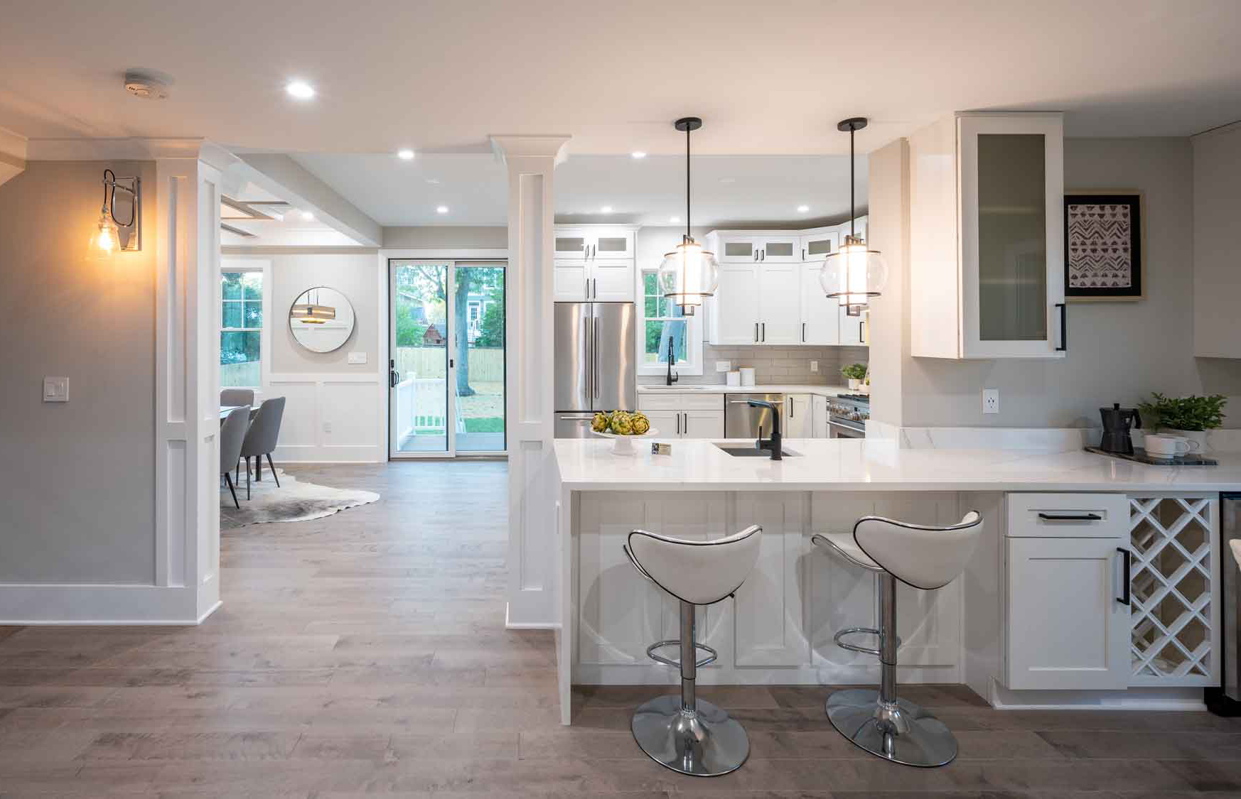 Kitchen renovation with quartz countertops, stainless appliances, white cabinets and ceramic tile backsplash